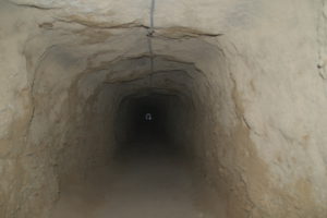 der ca. 100 Meter lange Tunnel ca. 2 Meter hoch, stockdunkel. Am Ende sieht man ein kleines Licht, der Ausgang