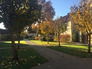 Eien kleine Allee führt nach hinten, rechts und hinten sind die Abteigebäude zu sehen.