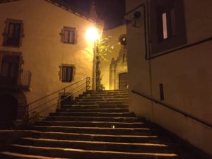 Eine Treppe führt zu Portal der kleinen Stadtkirche im Laternenlicht.